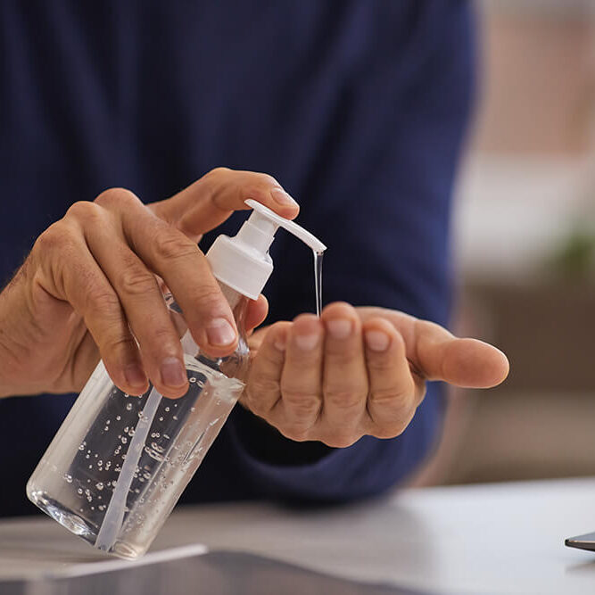 close-up-unrecognizable-mature-man-using-hand-sanitizer-while-washing-hands-workplace-copy-space