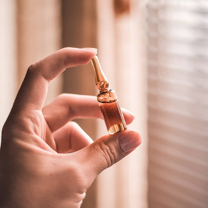 closeup-hand-holding-ampoule-sunlight-with-window