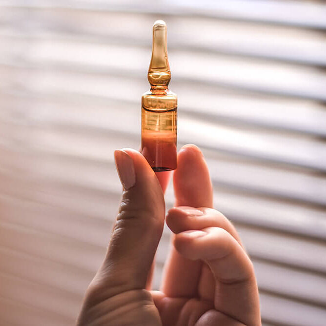 closeup-person-holding-ampoule-sunlight-with-window