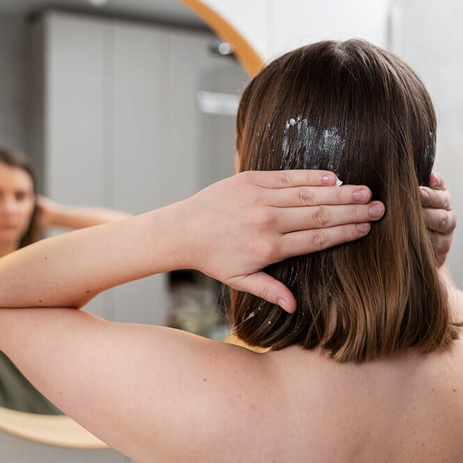 young-woman-applying-anti-dandruff-product