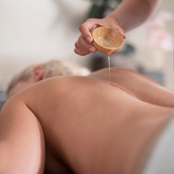 young-woman-using-massage-oil-her-client